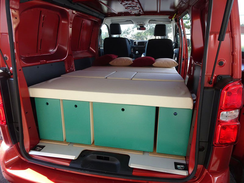 Interior de un Peugeot Expert camperizado con una cama